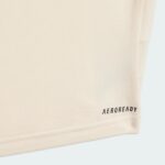 Close-up of beige fabric texture with a small corner of black text reading 'AEROREADY' in the bottom-right.