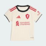 White football jersey front with red shoulder stripes, club crest, Adidas logo, and 'standard chartered' sponsor text; Aeroready badge visible.