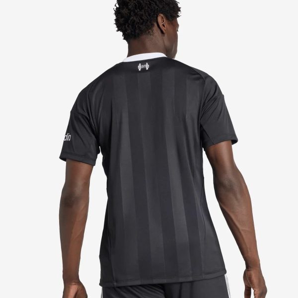 Back view of a man wearing a black striped athletic jersey with a white collar, facing away from the camera.