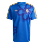 Blue Real Madrid football jersey with gold shoulder stripes and crest, front view.