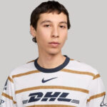 Portrait of a person wearing a white and gold striped sports jersey with DHL logo, against a gray backdrop.