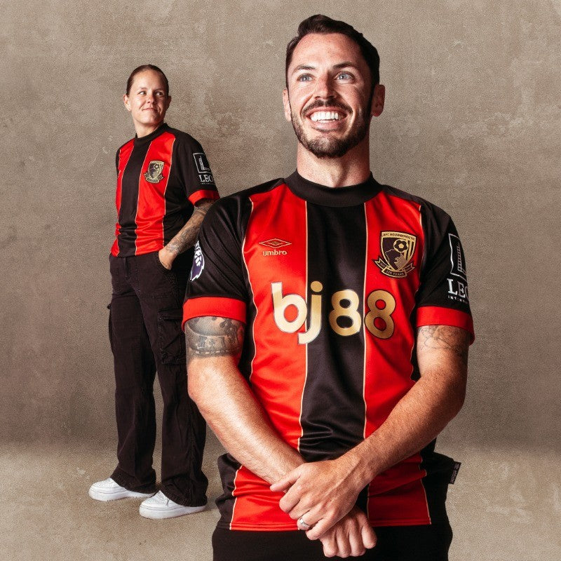 Jqj0xmu3cPDucnN | UAE SPORT STORE Two men in red-and-black striped football jerseys pose against a plain wall; one stands in background, the other smiles broadly in front.
