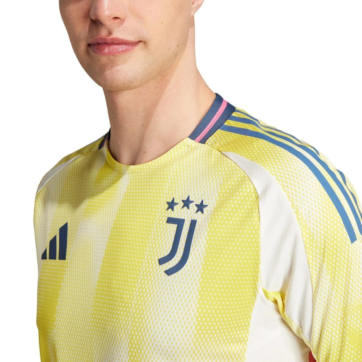 Close-up of a yellow Juventus football jersey on a man's upper torso, showing the collar and team emblem with stars on the chest edge