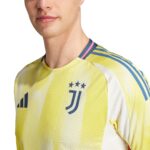 Close-up of a yellow Juventus football jersey on a man's upper torso, showing the collar and team emblem with stars on the chest edge