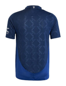 Back view of a blue athletic jersey with a geometric mesh pattern and curved hemline at the bottom edge on a plain background, showing sleeve logo on the left.