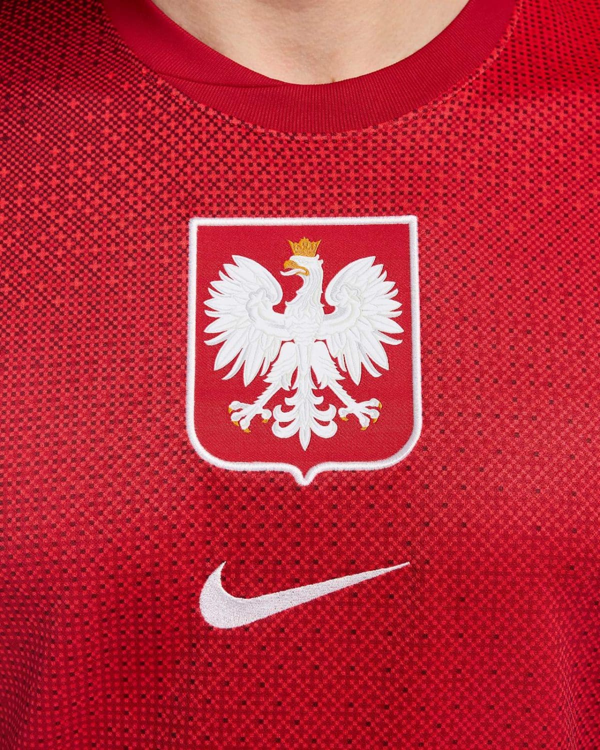 Red sports jersey featuring the Polish national emblem—a white eagle on a red shield—with a white Nike swoosh nearby.
