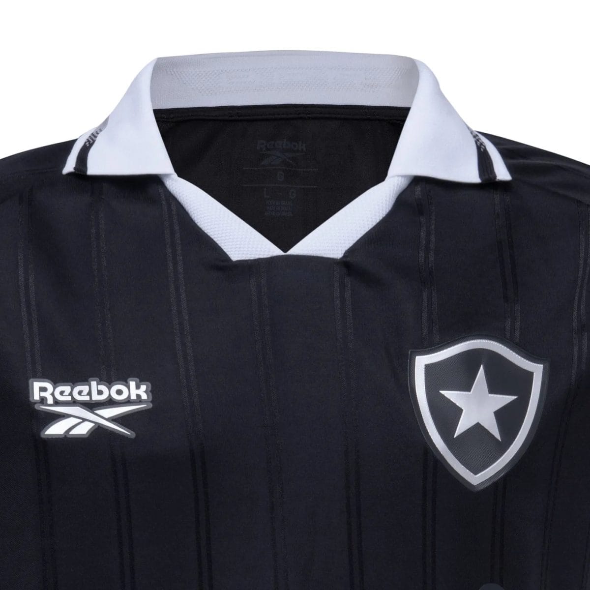 Dark navy soccer jersey with a white V-neck collar, featuring a Reebok logo on the left and a shield with a star on the right.