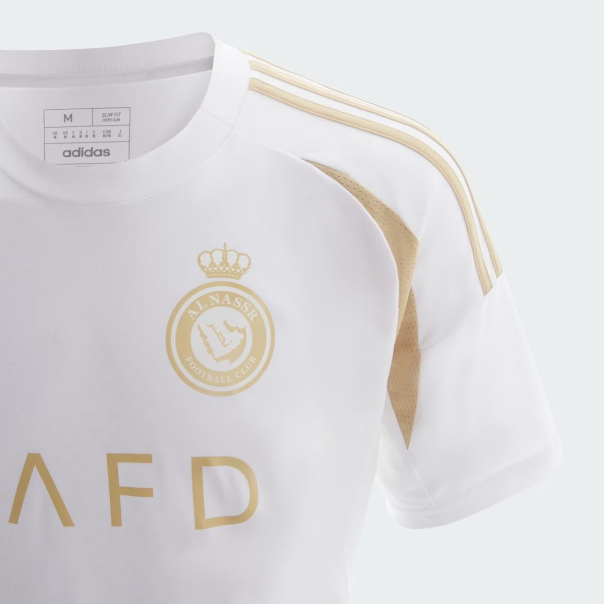 White football jersey showing a gold club crest and three gold shoulder stripes; Adidas branding faintly visible at neck area.