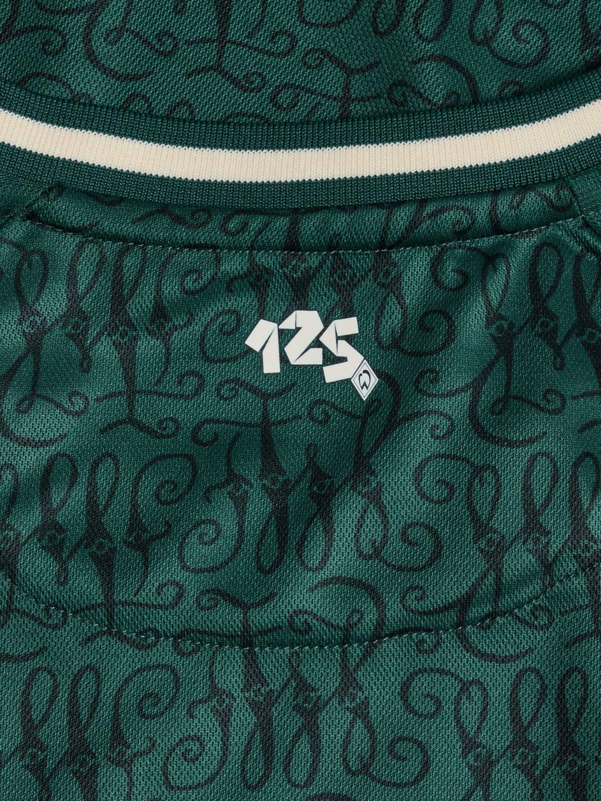 M4PipCbuO7rtKSo | UAE SPORT STORE Green fabric with a black cursive swirl pattern and a white '124' logo at the center; appears to be apparel material with a striped collar edge nearby.