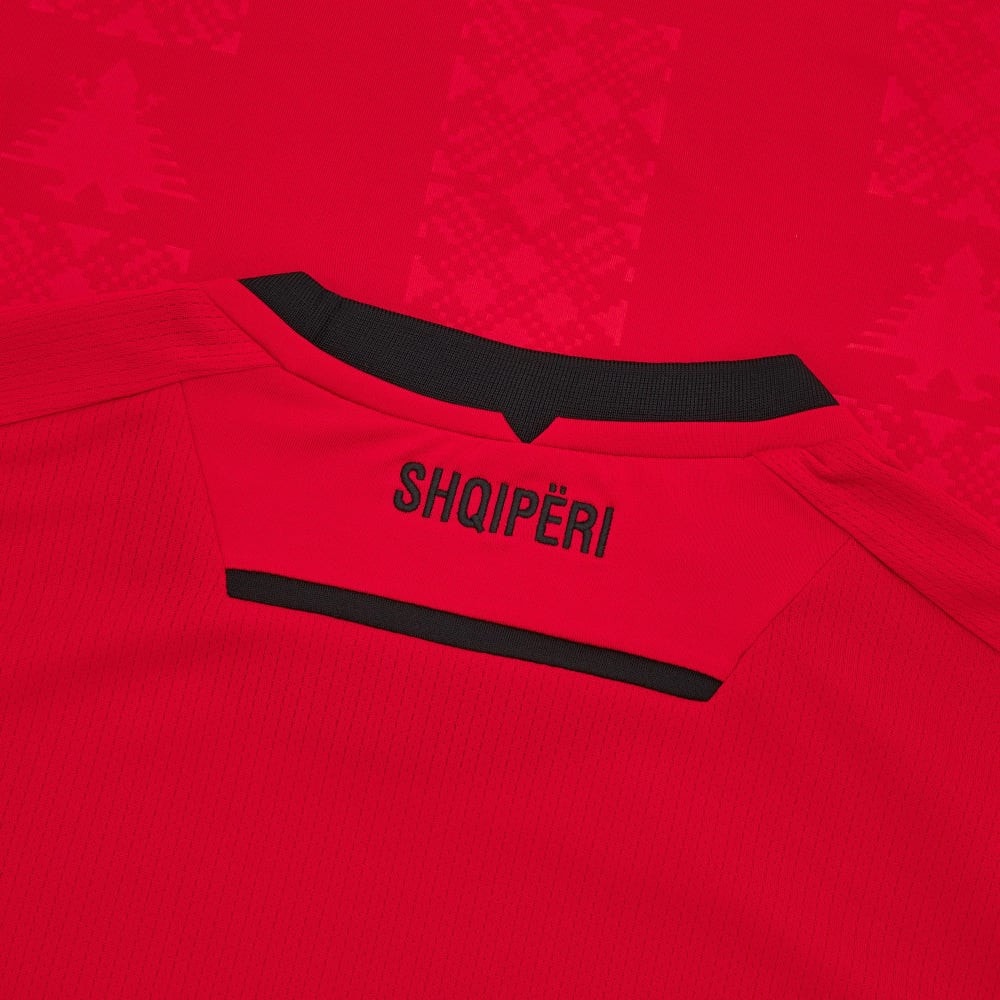 M9XQHrAqTLrPS23 | UAE SPORT STORE Red athletic jersey neck area with black trim and the word SHQIPËRI in black letters on red fabric.