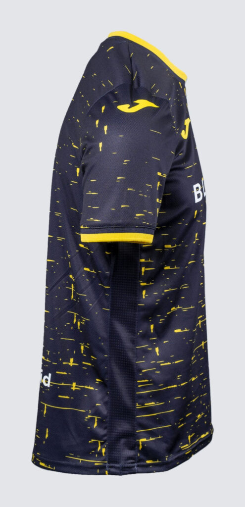 Side view of a navy blue sports jersey with yellow paint-splatter pattern and yellow trim on the collar and sleeves.
