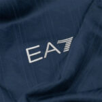Close-up of the silver EA7 logo embroidered on dark blue fabric (sportswear).