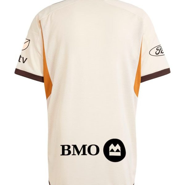 Cream-colored sports jersey back view with brown trim, orange side panels, and sponsor logos (BMO) on lower back.