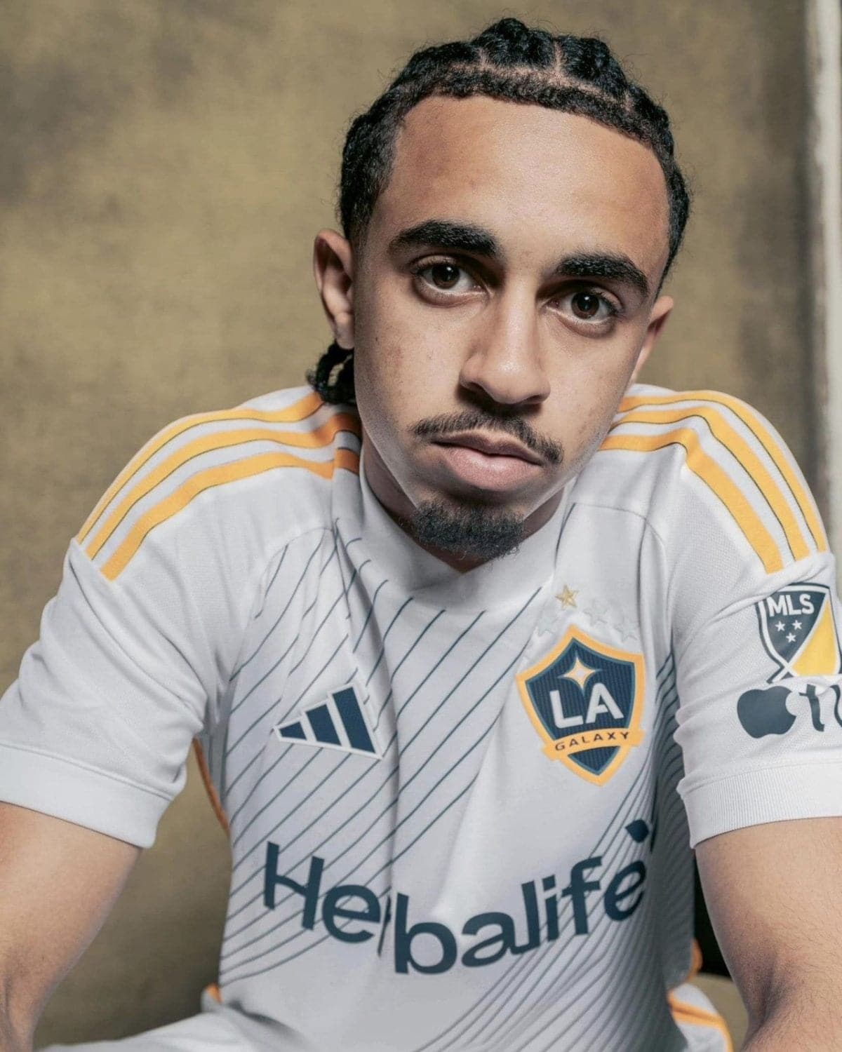 Close-up portrait of a young man in an LA Galaxy jersey looking at the camera.