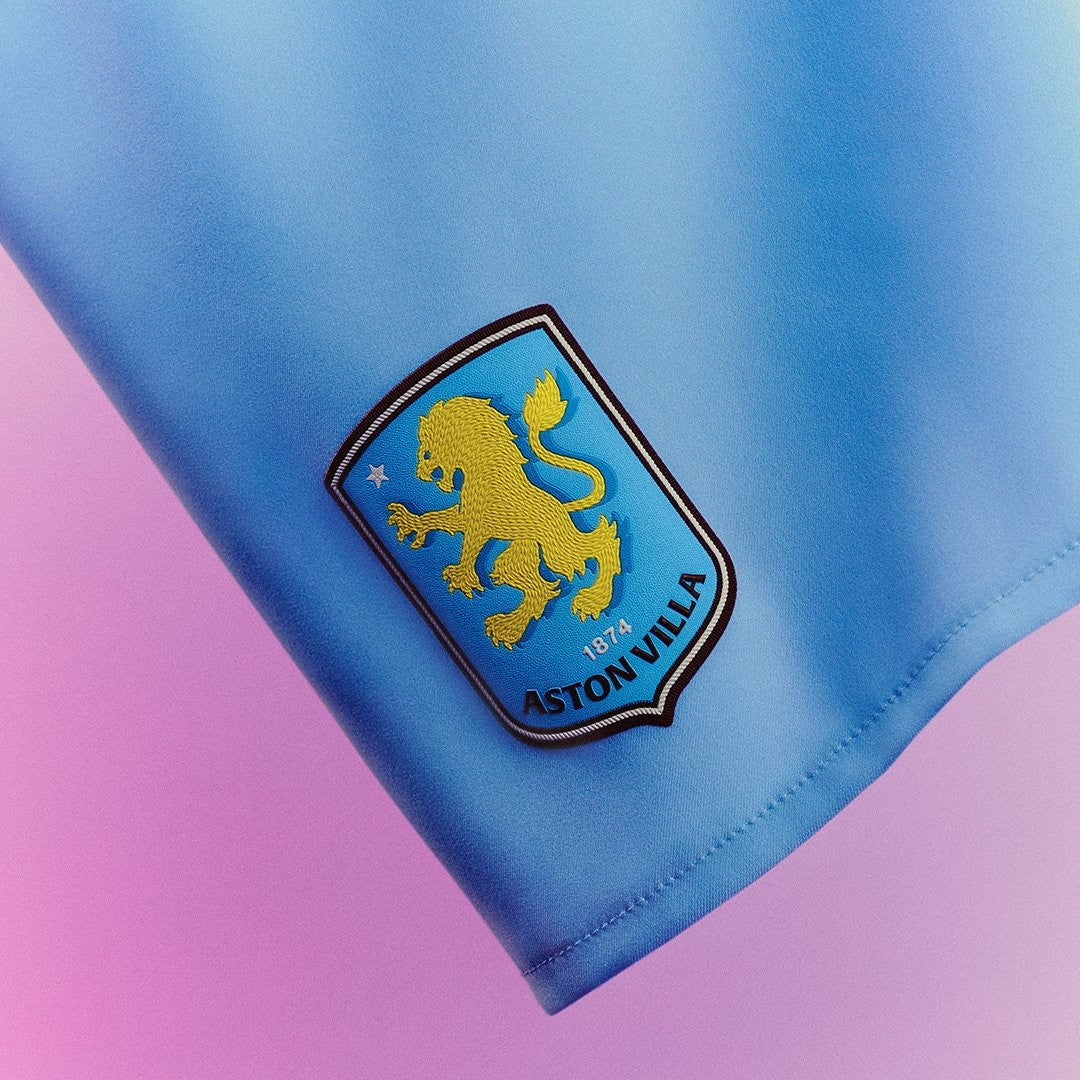 MvqnPvSxccvPFPe | UAE SPORT STORE Close-up of Aston Villa crest embroidered on blue fabric, featuring a gold lion and 1874.