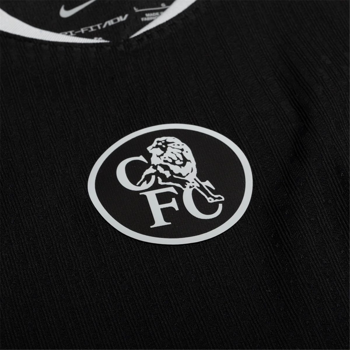 Close-up of a black fabric with a white circular logo featuring a dinosaur skeleton inside the circle.