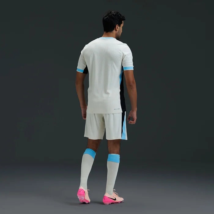 NK_NKIM6845_280IT26_2050005174587_3 | UAE SPORT STORE Soccer player shown from behind in a white kit with blue accents and pink cleats.