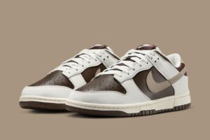 Pair of white and brown Nike sneakers with white laces on a beige background, shown from the front-left side.