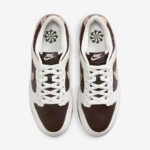 Top-down view of two white and brown Nike sneakers with maroon panels, white laces, and black Nike logos on the tongues.