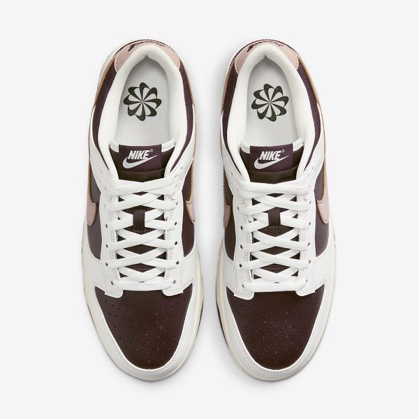 Top-down view of two white and brown Nike sneakers with maroon panels, white laces, and black Nike logos on the tongues.