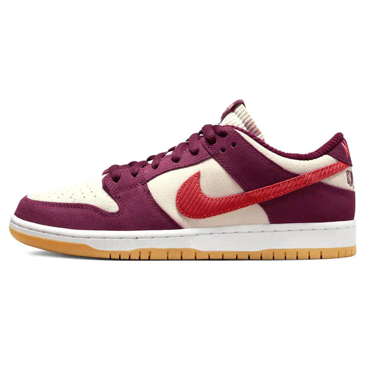 Nike-SB-Dunk-Low-Skate-Like-a-Girl_720x_d04487c7-ca70-48ef-b434-e7d742bd806e | UAE SPORT STORE Purple and cream Nike sneaker with orange swoosh on a white background, low-profile basketball shoe style.