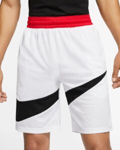 Close-up of a person wearing white athletic shorts with a red elastic waistband and a black diagonal stripe on the leg area.