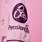 Close-up of a pink bottle sleeve with a black circular logo and the word 'Pension' on a pink background.