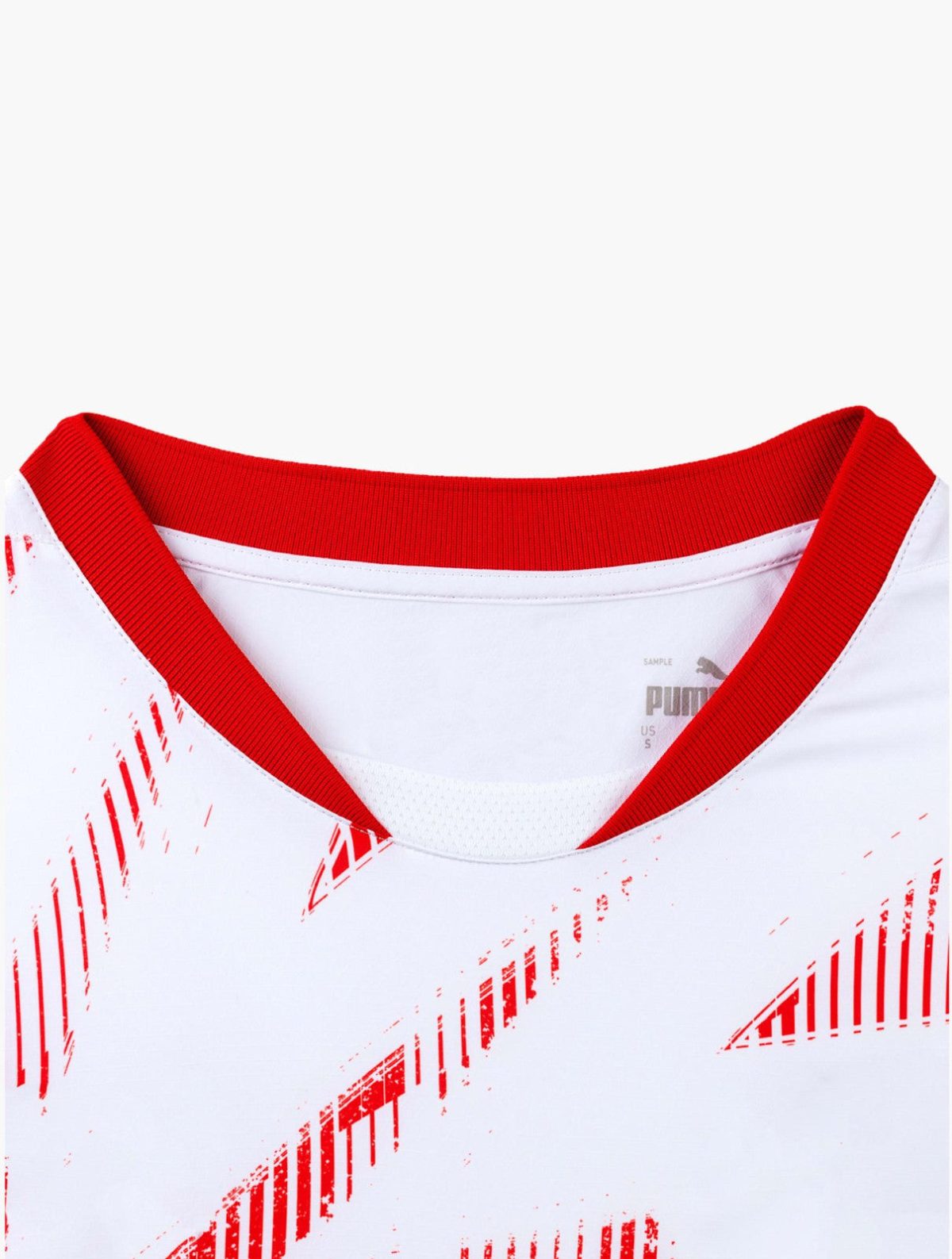 Close-up of a white shirt collar with red ribbed trim and red diagonal graphic pattern, brand visible inside neck.