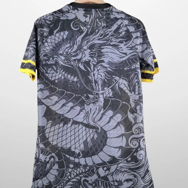 Back view of a gray T-shirt with an ornate black dragon pattern and yellow sleeve cuffs, hanging on a wooden hanger.