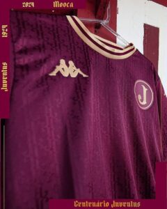 Maroon Juventus football jersey with the Kappa logo and circular J crest, hung on display in a burgundy frame.