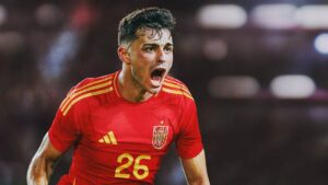 Soccer player in red Spain jersey number 26 shouting on the field during a match.