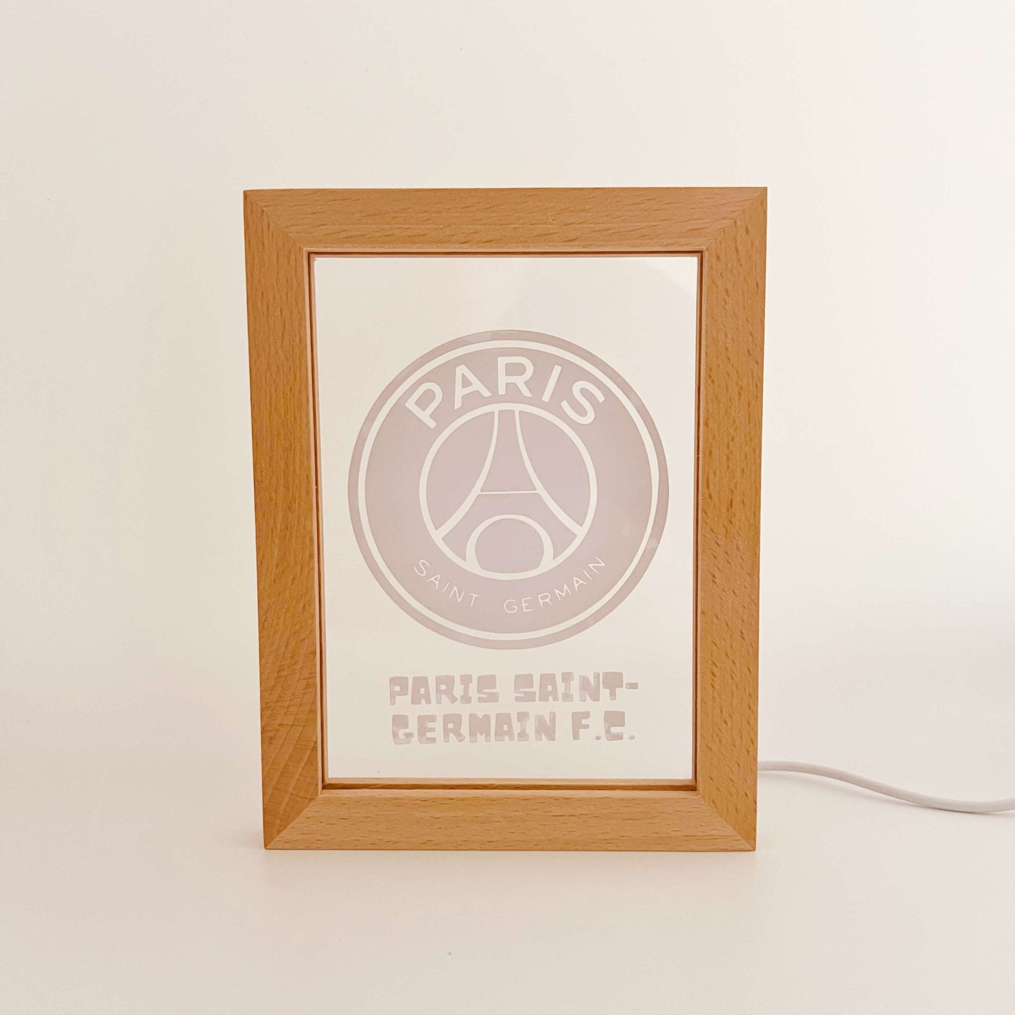 Paris-Saint-Germain-Wooden-Frame-Light-scaled-1 | UAE SPORT STORE Wooden frame displaying a PSG logo and text Paris Saint‑Germain football club on a white surface.