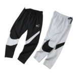 Two Nike jogger pants laid side by side: black pair with white swoosh, and light gray pair with black swoosh.