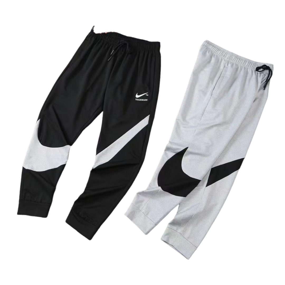 PhotoRoom-20220401_165925_162889fc-674a-4214-960c-ed482c97d534 Two Nike jogger pants laid side by side: black pair with white swoosh, and light gray pair with black swoosh.