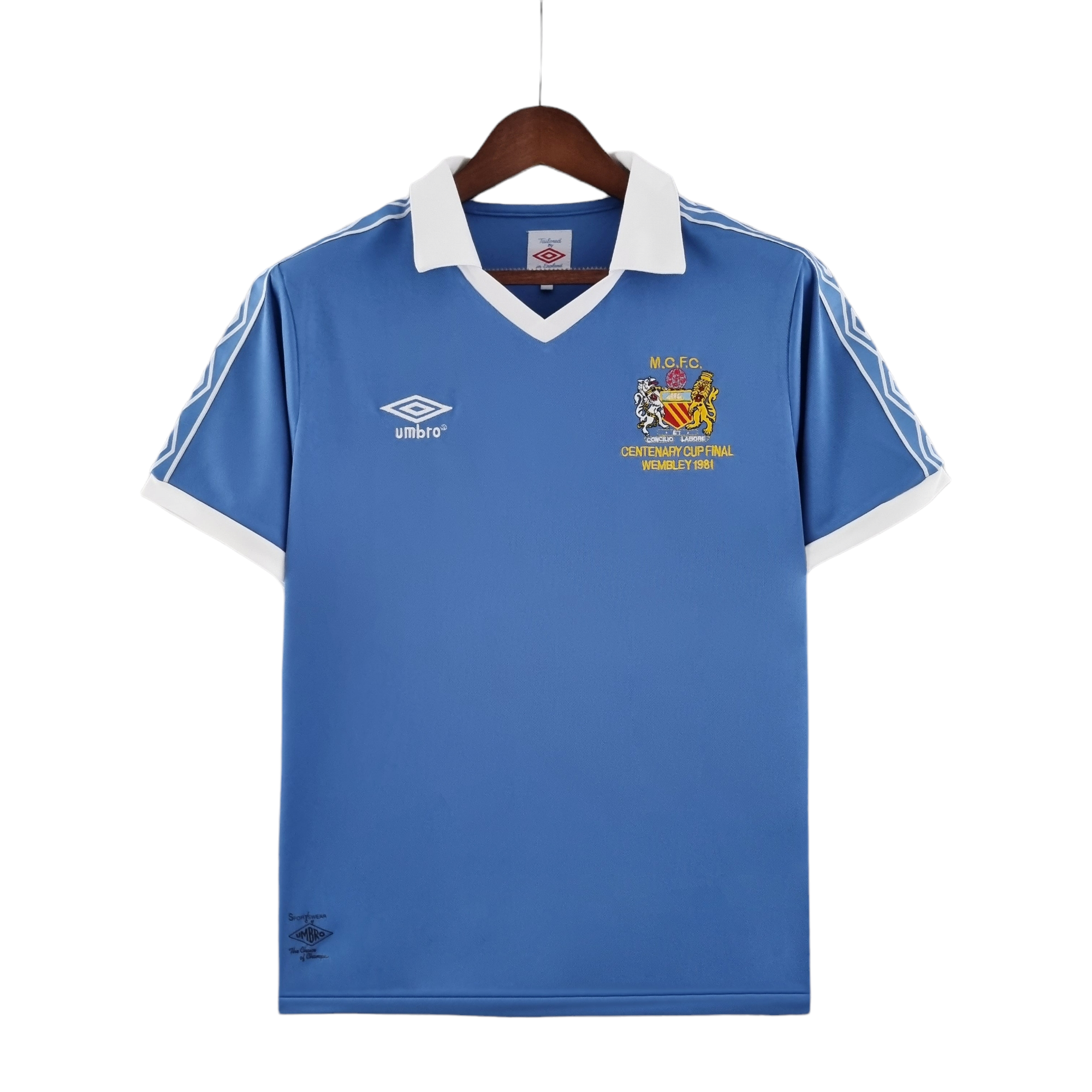 PhotoRoom-20220714_181430_a12f5ded-b575-4a61-8d23-2eacb4e45606 | UAE SPORT STORE Blue football jersey on a wooden hanger with a white collar, featuring the Umbro logo on the left chest and a crest with Wembley 1981 text on the right.
