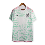 White Adidas jersey with green dot pattern, pink shoulder stripes, and Mexico crest on the chest, hanging on a wooden hanger.