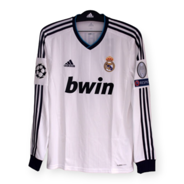 White Real Madrid home soccer jersey on a hanger with Adidas stripes, Real Madrid crest and bwin sponsor visible on the chest.