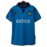Blue polo-style soccer jersey on a hanger, showing a crest on the left chest and the sponsor text 'EIDOS' across the front.