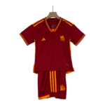 Maroon soccer jersey with orange piping and a wolf crest on the chest, displayed on a wooden hanger with matching shorts beside it.