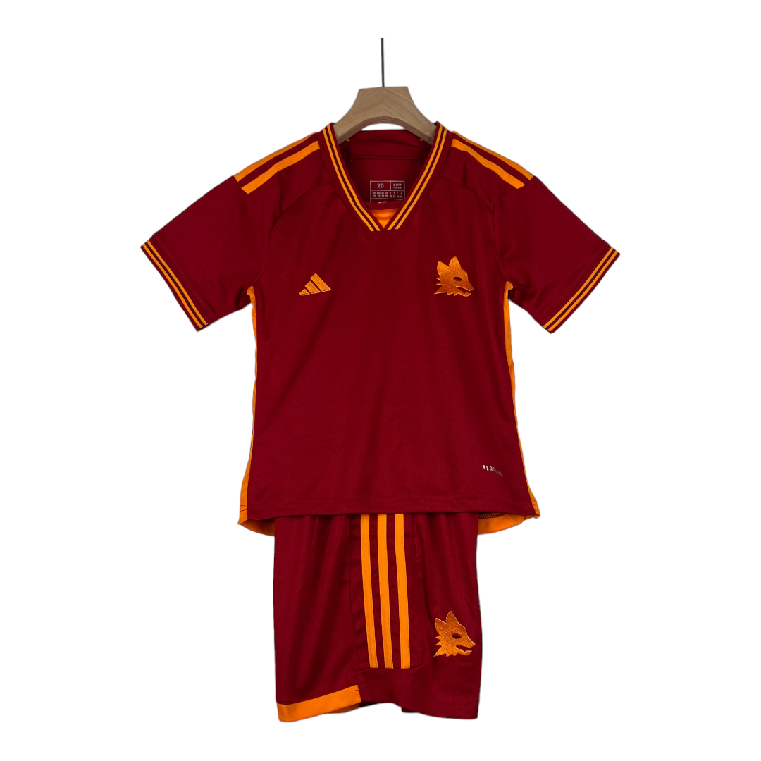 PhotoRoom-20230728_064128_2e105257-d020-487f-af90-d37dc224647a Maroon soccer jersey with orange piping and a wolf crest on the chest, displayed on a wooden hanger with matching shorts beside it.