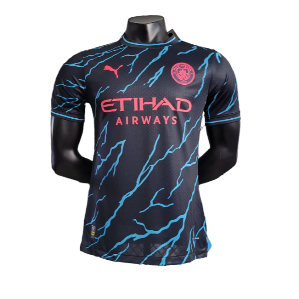 Manchester City soccer jersey on a mannequin: navy kit with pink Etihad Airways sponsor and blue lightning patterns.