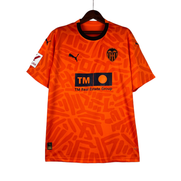 Orange Valencia CF football jersey on a hanger, featuring the black Puma logo and club crest.
