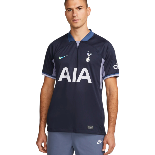 Navy Tottenham Hotspur jersey with AIA sponsor on a man standing, featuring a blue collar and Nike swoosh on the chest.