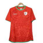 Red soccer jersey on a hanger with green trim at the collar and sleeves, featuring a Kappa logo and a team crest on the left chest.