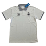 White polo shirt with Real Madrid crest and Adidas logo on the chest, black striped collar and sleeve cuffs, tag attached