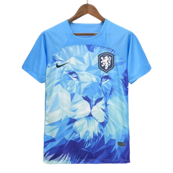 Blue soccer jersey on a wooden hanger featuring a geometric lion design, with a Nike swoosh and a shield crest with a lion.