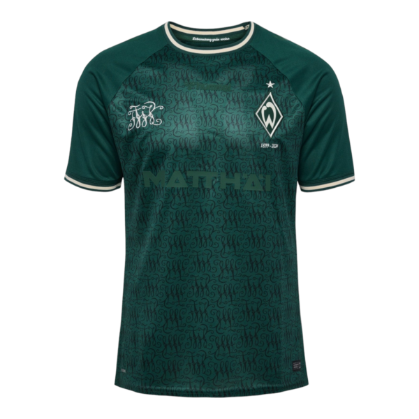 Front view of a green patterned soccer jersey with a club crest on the left chest and a sponsor word across the midsection.
