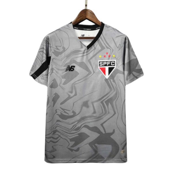 Gray camouflage São Paulo FC soccer jersey on a hanger, featuring the SPFC crest, New Balance logo, and a black shoulder stripe.