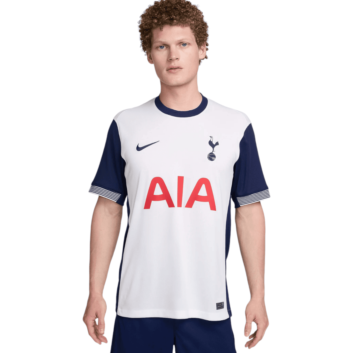 Young man wearing a white Tottenham Hotspur football jersey with navy sleeves, Nike swoosh, and AIA sponsor.