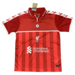 Red Liverpool FC home jersey with vertical stripes and white sponsor text 'Standard Chartered' on front.